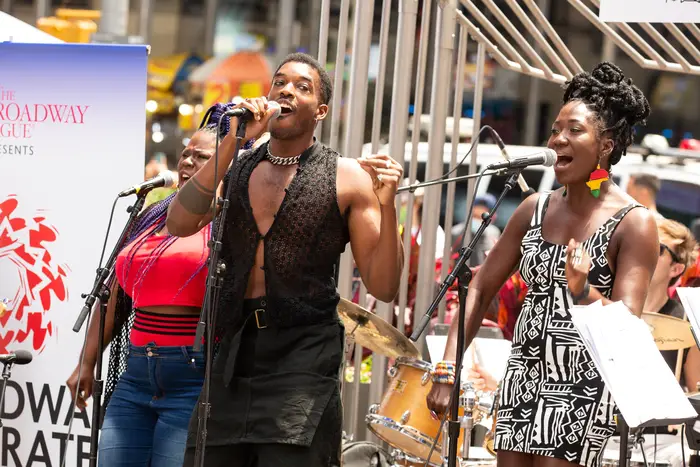 Singers performing on an outdoor stage in Times Square.